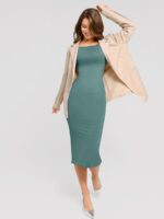 Mujer con vestido verde y blazer.