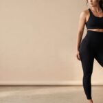 Mujer con mallas moldeadoras negras y top deportivo, banner principal.