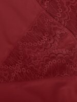 Detalle de pierna de encaje rojo con borde festoneado.