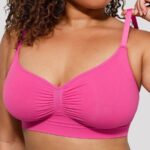 Mujer con sujetador moldeador rosa fucsia sin costuras, sujetando el tirante.