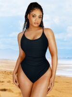 Mujer con bañador negro con fruncido reductor en la playa.