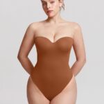 Mujer con body tanga marrón caramelo con aros y escote corazón.
